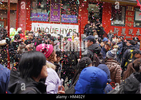 Confettis et paillettes de poppers parti géant tombe sur une foule de personnes célébrant le Nouvel An lunaire dans Chinatown NYC Banque D'Images