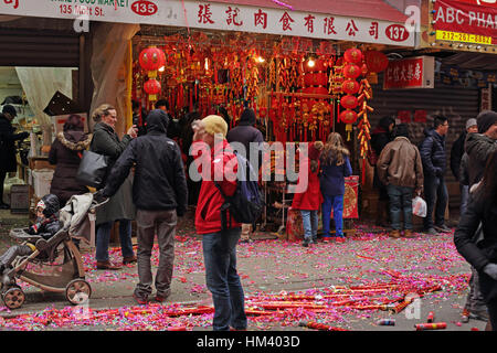 Colorful confetti rouge du parti géant poppers portées le sol en face d'une nouvelle année lunaire Chinatown shop Banque D'Images