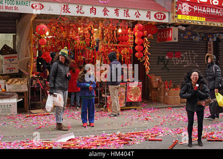 Colorful confetti rouge du parti géant poppers portées le sol en face d'une nouvelle année lunaire Chinatown shop Banque D'Images