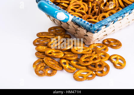 Bretzels doux sur un beau tissu dans un panier en osier sur un whi Banque D'Images