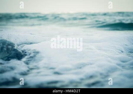 L'eau de mer et la mousse de près. Cool ton, faible angle Banque D'Images