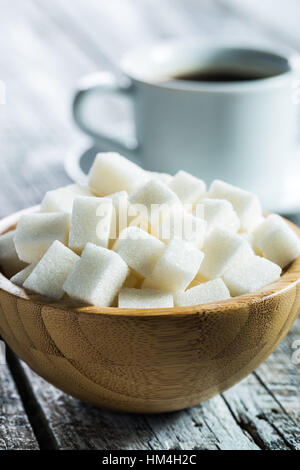 Cubes de sucre blanc dans un bol en bois. Banque D'Images