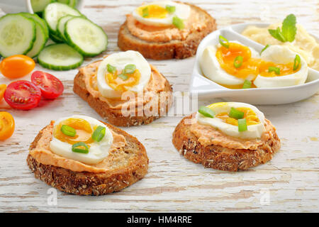 Sandwiches avec de la pâte de saumon et oeuf sur le fond en bois blanc Banque D'Images