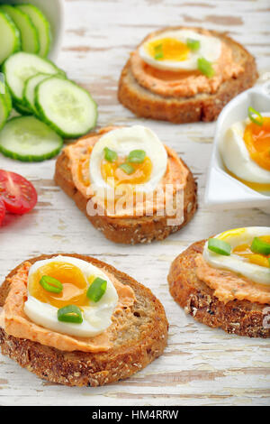 Sandwiches avec de la pâte de saumon et oeuf sur le fond en bois blanc Banque D'Images