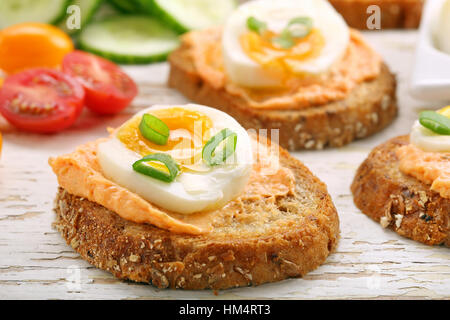 Sandwiches avec de la pâte de saumon et oeuf sur le fond en bois blanc Banque D'Images