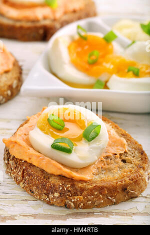 Sandwiches avec de la pâte de saumon et oeuf sur le fond en bois blanc Banque D'Images