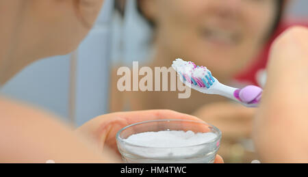 Femme l'éclaircissement des dents avec du bicarbonate de sodium Banque D'Images