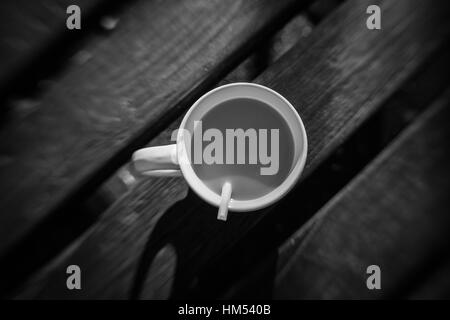 Café non fini sur une table en bois dans un café en plein air Banque D'Images