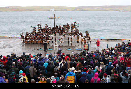 Regarder la foule en tant que membres de l'équipe de Jarl vêtus de costumes de Vikings assembler par la cuisine après une marche à travers la rue à Lerwick sur les îles Shetland pendant le festival Up Helly Aa Viking. Banque D'Images