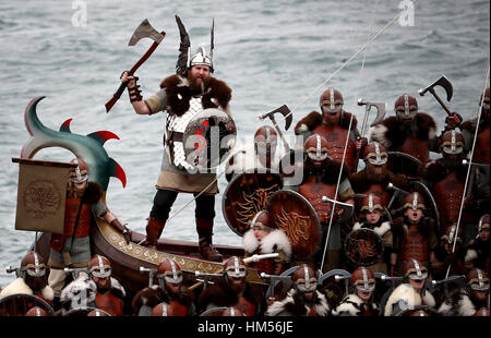 Les membres de l'équipe de Jarl vêtus de costumes Viking sur la cuisine après une marche à travers la rue à Lerwick sur les îles Shetland pendant le festival Up Helly Aa Viking. Banque D'Images