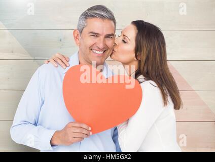 Femme romantique, baiser sur la joue de l'homme forme holding heart Banque D'Images