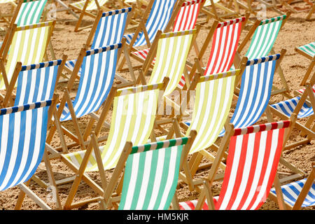Des rangées de chaises vides en rouge,jaune,vert et bleu couleurs sur une plage. Banque D'Images