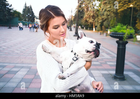 Femme et un chiot buldog français dans un parc Banque D'Images