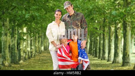 Happy Family standing in park avec le drapeau américain Banque D'Images