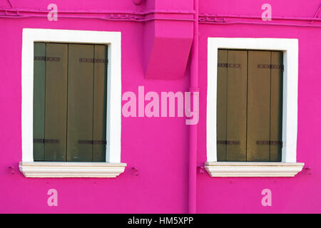 Volets fermés aux couleurs vives rose pourpre contre mur de chambre à Burano - couleurs de Burano, Venise, Italie en janvier Banque D'Images
