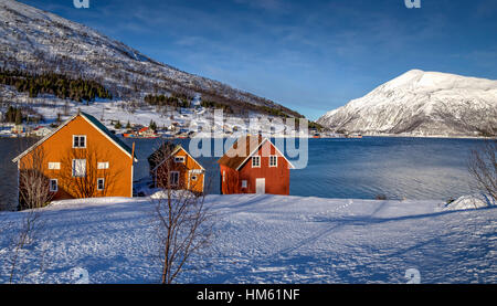 Maisons colorées vu en hiver le long du fjord, dans le Nord de la Norvège, au-delà du cercle arctique. Banque D'Images