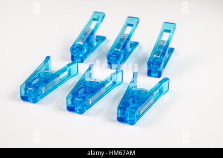 Pinces à linge en plastique bleu sur fond blanc. Banque D'Images