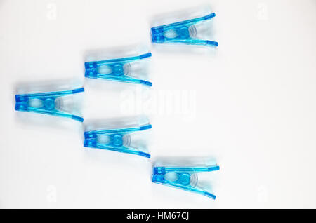 Pinces à linge en plastique bleu sur fond blanc. Banque D'Images