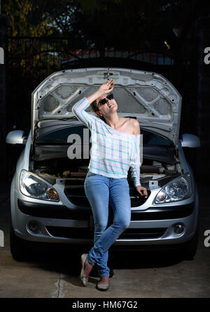 Jeune fille avec de l'aide d'attente voiture cassée Banque D'Images