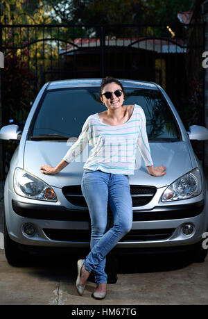 Happy smiling young girl avec en face de voiture Banque D'Images