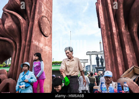 Les personnes qui ont du temps de loisirs près du monument des héros (10 novembre) et de la statue de Soekarno-Hatta à Surabaya, Java-est, Indonésie. Banque D'Images