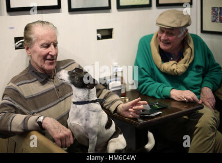 Morris, un six ans Jack Russell assis sur son propriétaire Fred Davies tour, en tant que collègues Michael patron Danvers-Walker regarde sur, dans Cafe Diana, Londres. Banque D'Images