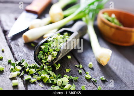 Oignon vert sec et le couteau sur une table Banque D'Images