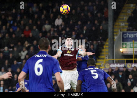 Burnley's Michael Keane tente un en-tête au but tandis que sous la pression de la ville de Leicester Daniel Drinkwater durant la Premier League match à Turf Moor, Burnley. Banque D'Images