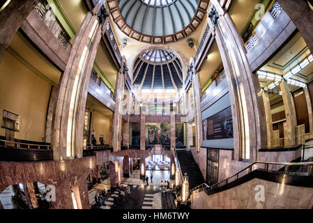 Museo Del Palacio de Bellas Artes Art déco intérieur Mexico // MEXICO CITY, Mexique — le hall principal du Museo del Palacio de Bellas Artes présente une architecture Art déco avec des colonnes de marbre et des puits de lumière ornés d'un dôme. Ce vestibule central sert d'entrée principale aux galeries murales du musée, qui abritent des œuvres d'artistes mexicains de premier plan tels que Diego Rivera, David Alfaro Siqueiros et José Clemente Orozco. Le Palacio de Bellas Artes, achevé en 1934, combine des éléments extérieurs Art Nouveau avec des intérieurs Art déco et fonctionne comme le premier centre culturel du Mexique. Le bui Banque D'Images