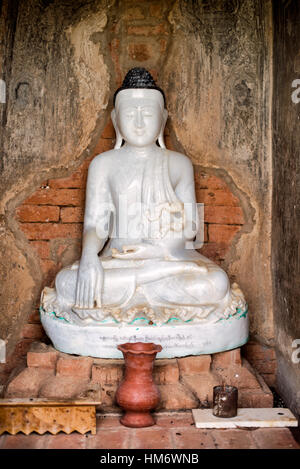 Statue de Bouddha dans le Temple Bagan Myanmar // BAGAN, Myanmar — Une statue de Bouddha blanche se trouve dans l'un des nombreux petits temples dispersés dans la plaine de Bagan. La zone archéologique de Bagan contient plus de 2 000 temples, pagodes et monastères bouddhistes survivants, issus d'environ 10 000 structures originales construites entre le XIe et le XIIIe siècle. Ces temples plus petits, contenant souvent des images uniques de Bouddha, sont dispersés parmi les pagodes les plus importantes dans toute la zone archéologique de 26 miles carrés (67 kilomètres carrés). L'ancienne ville de Bagan a servi de capitale au Kin païen Banque D'Images