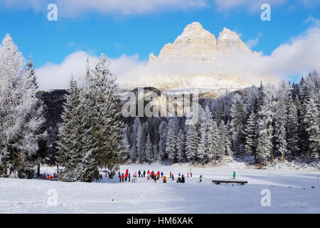 Tre Cime di Lavaredo et childrenskating sur l'Antorno glacé lake, près de Misurina. Banque D'Images