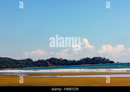 Plafonné blanc vagues roulent sur le sable doré de Playa Dominical dominical, Costa Rica. Banque D'Images