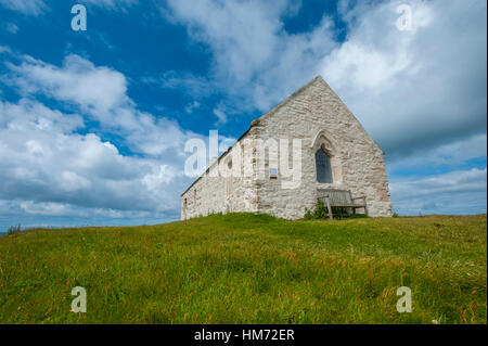 Cwyfan Église église dans la mer anglesy. L'église avait un mur défensif construit tout autour pour éviter les errosion, il siège maintenant seul dans la baie coupée Banque D'Images