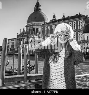 Un autre monde de vacances. Portrait of smiling woman in fur hat élégant à Venise, Italie portant masque de Venise Banque D'Images