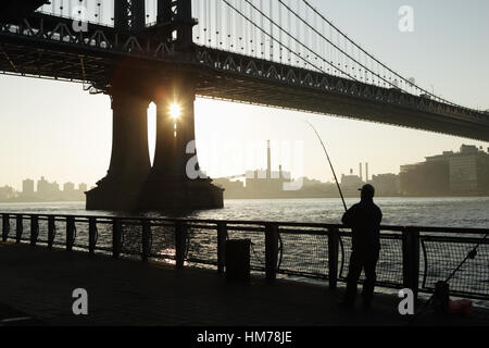Pêche à l'homme de l'Est River Esplanade avec vue sur le front de Brooklyn sous le pont de Manhattan Banque D'Images
