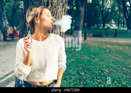 Teenage girl using cigarette électronique Banque D'Images