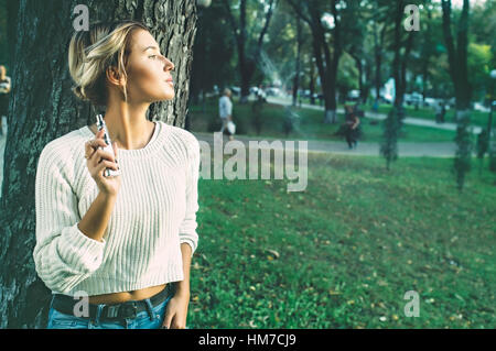 Teenage girl using cigarette électronique Banque D'Images