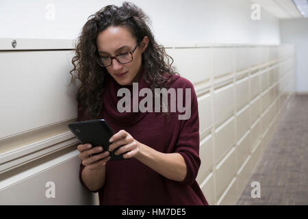 Young woman using digital tablet in corridor Banque D'Images