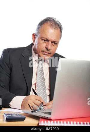 L'homme d'affaires s'engagent sur un bureau avec ordinateur portable isolé sur fond blanc Banque D'Images