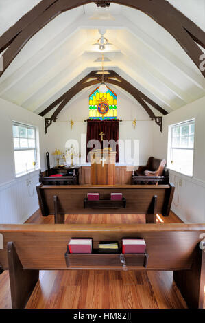 Petite église intérieur avec des bancs et de chaire, chapelle vide avec un plafond voûté et des vitraux, à l'intérieur de la masse,livres, croix. Banque D'Images