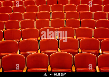 Sièges de théâtre vide rouge vibrant avec accoudoirs en bois, une salle de concert de stade pas d'auditoire ou parrains, old style coin Banque D'Images