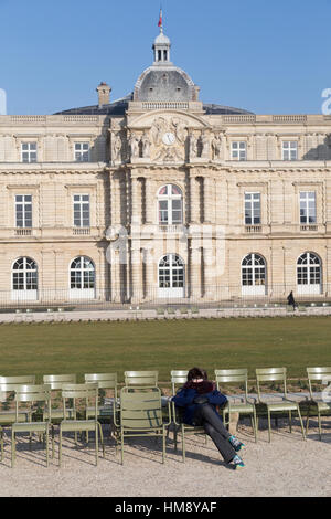 Woman le soleil d'hiver à l'avant du Palais du Luxembourg, à Montparnasse, dans le 14ème arrondissement de Paris France Banque D'Images