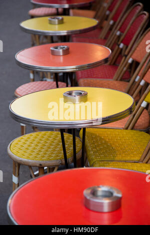 Tables rouge et jaune à l'extérieur d'un café à Montparnasse dans le 14ème arrondissement de Paris en hiver Banque D'Images