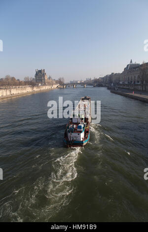 Barge transportant les ordures le long de la Seine à Paris en hiver Banque D'Images