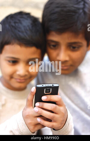 Asian boy playing sur téléphone mobile et le frère à la recherche sur le téléphone Banque D'Images