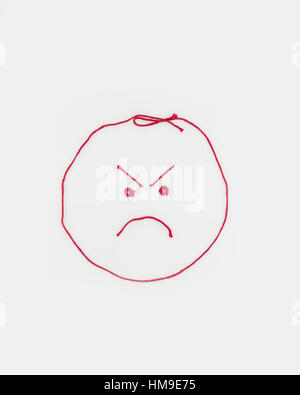 Notion conceptuelle. Un visage en colère rouge en forme de fil. Découpe. Banque D'Images