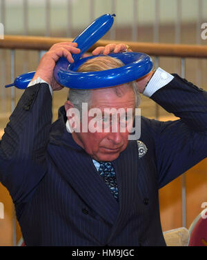 Le Prince de Galles est montré comment faire des chapeaux à partir de ballons au cours d'une visite au Collège de Yavneh, une école juive orthodoxe à Borehamwood, Hertfordshire. Banque D'Images