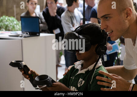 Homme mûr aide les gens d'utiliser correctement un système de RV Banque D'Images