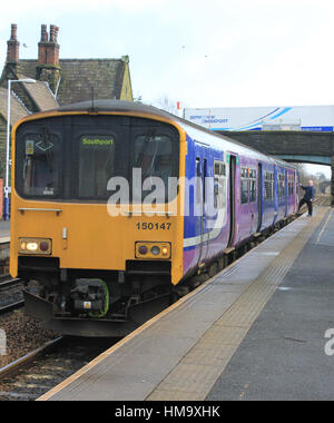 Un garde, d'un service de train du Nord rejoint son train à Burscough Bridge. Banque D'Images