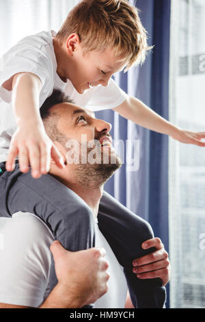 Father carrying son on cou Banque D'Images
